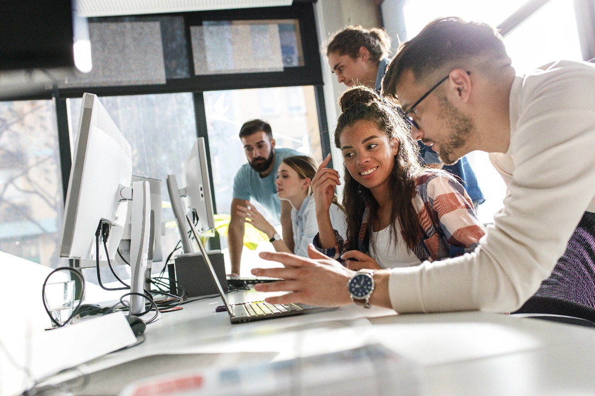 Team collaborating with laptops in a modern office